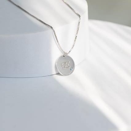 Silberner Anhänger mit blauem Diamant und Gravur eines Buchstabens Sager