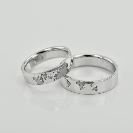 Platin-Trauringe mit Gravur der Kontinente und Diamant Zeoni