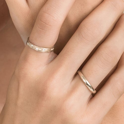 Goldene Eheringe mit von Hand gravierter Oberfläche aus Haselnussgold Cley