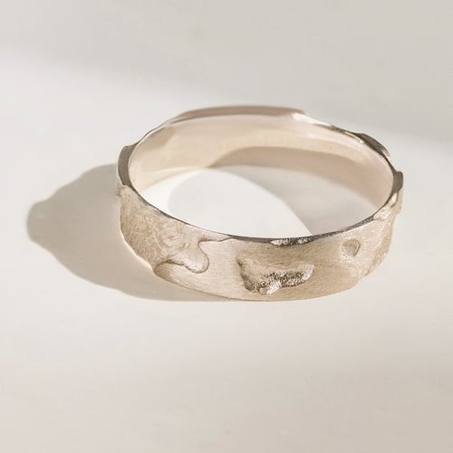Goldene Eheringe mit von Hand gravierter Oberfläche aus Haselnussgold Cley