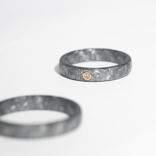 Leicht gerundete Eheringe aus Carbon mit Diamant Petrus