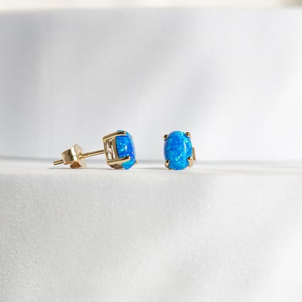 Blaue Opale in ovaler Form in goldenen Ohrringen Qati