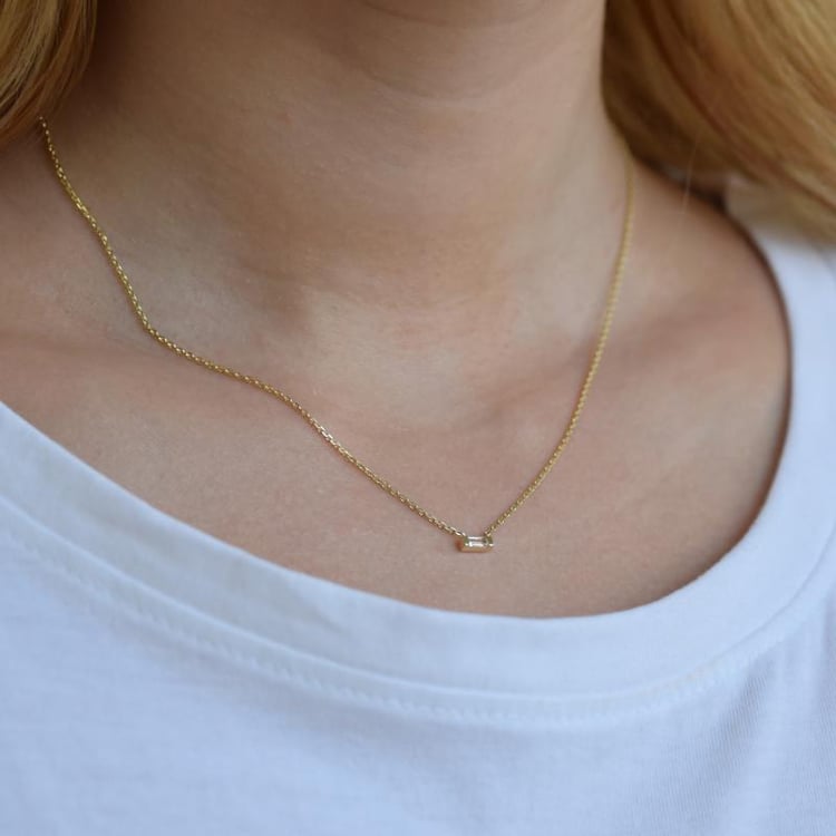 Halskette aus Gold mit Baguette Saphir auf dem Hals 20716