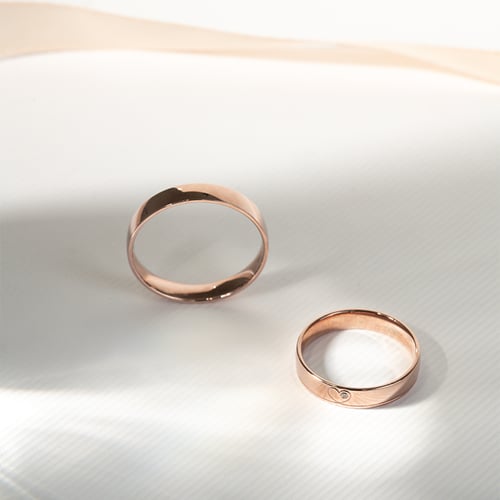 Goldene Eheringe mit einem Herzen und einem Diamanten Maline