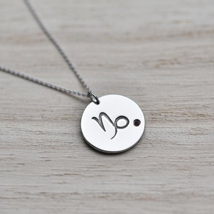 Silberner Anhänger mit Sternzeichen und Granat Steinbock