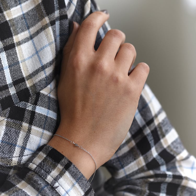 Diamant Würfel auf dem Goldarmband auf dem Arm 62264