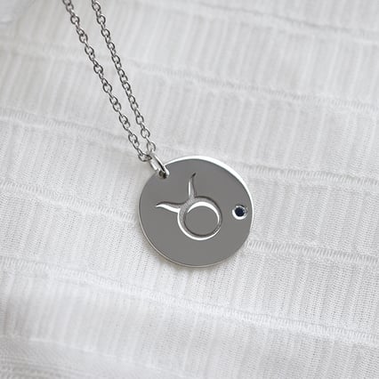 Silberner Anhänger mit Sternzeichen und einem blauen Saphir Stier