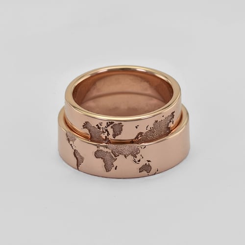 Goldene Trauringe mit Gravur der Weltkarte und Diamant Zeoni
