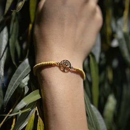 Armband mit einem silbernen Anhänger in Form des Lebensbaums Wicks