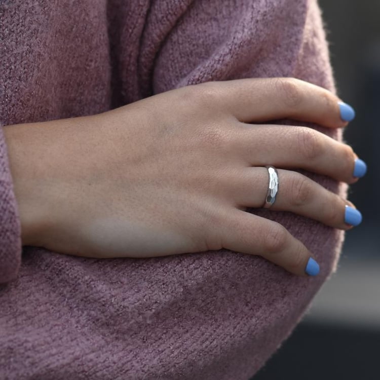 Weißgoldener gehämmerter Ring auf dem Finger 49821