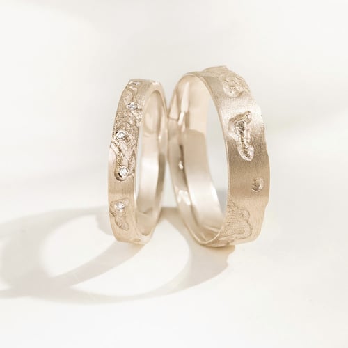Goldene Eheringe mit von Hand gravierter Oberfläche aus Haselnussgold Cley