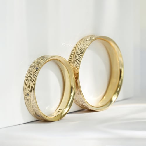 Eheringe mit einer Gravur wie eine Holzmaserung und Diamanten Dyanna