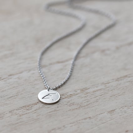 Silberner Anhänger mit Diamant und Gravur eines Buchstabens Sager