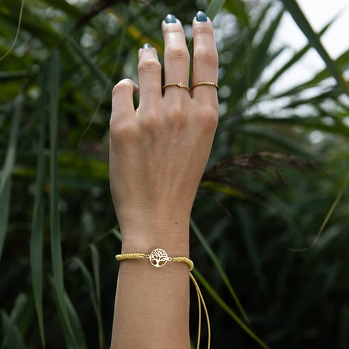 Armband mit einem silbernen Anhänger in Form des Lebensbaums Wicks