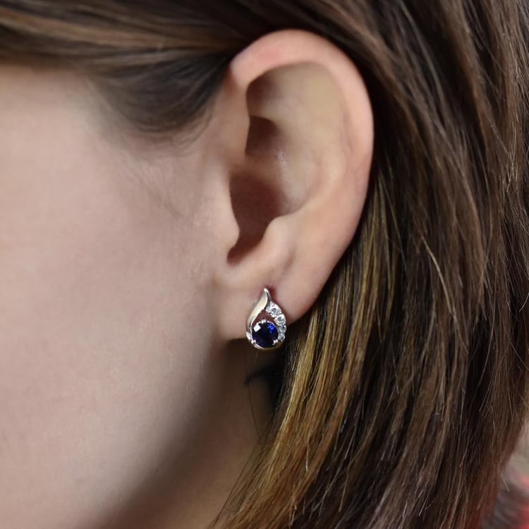 Silberne Ohrringe mit Saphir auf dem Ohr 14708