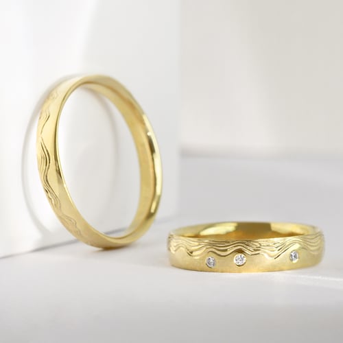Eheringe mit von Hand gravierten Wellen und Diamanten Laurien
