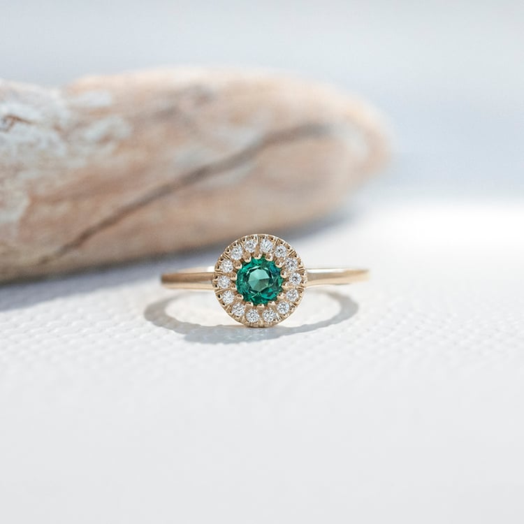 Goldener Halo Ring mit Smaragd umgeben von Diamanten Tafne 111599