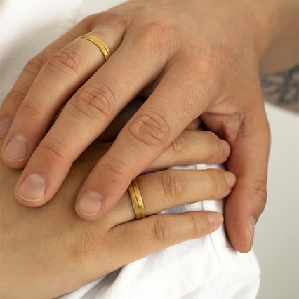 Goldene Eheringe mit gekratzter Oberfläche Alesha