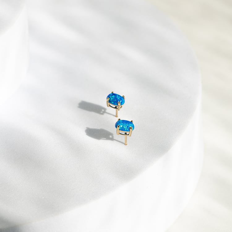 Blaue Opale in ovaler Form in goldenen Ohrringen Qati 145535