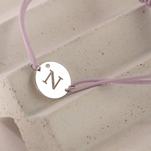 Armband mit einem silbernen Anhänger mit einem Diamanten und Gravur eines Buchstabens Frey