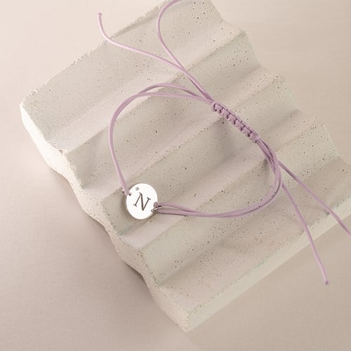 Armband mit einem silbernen Anhänger mit einem Diamanten und Gravur eines Buchstabens Frey
