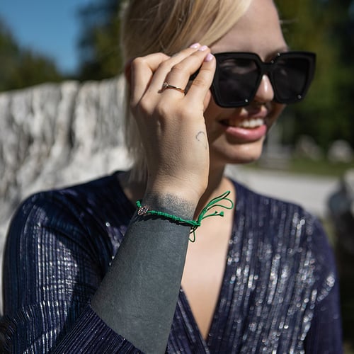 Armband mit einem silbernen Anhänger in Form der Weltkarte Globe