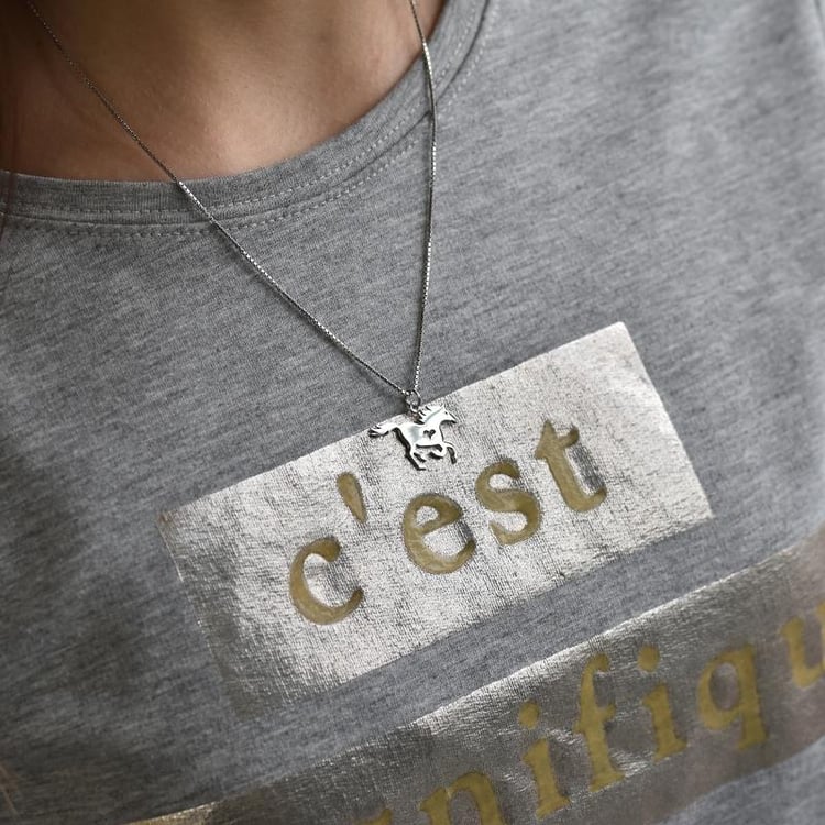 Dame mit silbernem Anhänger im Form von Pferd 39651