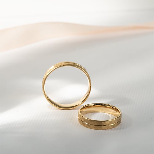 Goldene Eheringe mit gekratzter Oberfläche Alesha
