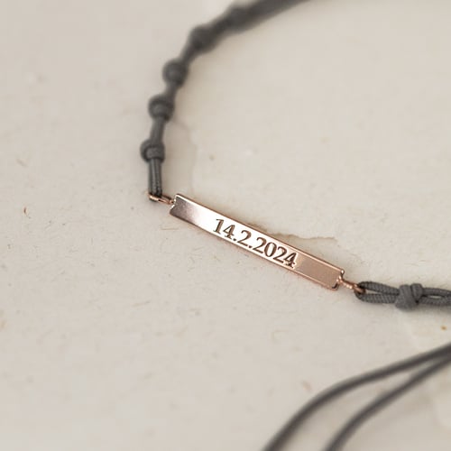 Armband mit einem silbernen Anhänger mit Gravur Bar