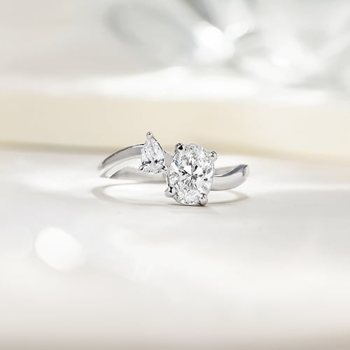 Verlobungsring in Wellenform mit einem tropfenförmigen und einem ovalen Lab Grown Diamante