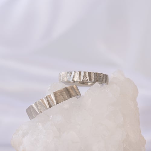 Goldene Eheringe mit matter Oberfläche und Diamanten Kristia