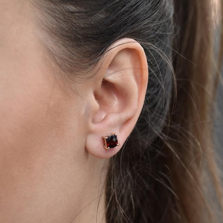 Goldene Ohrringe mit Granat in Kissenform auf der Dame 31158