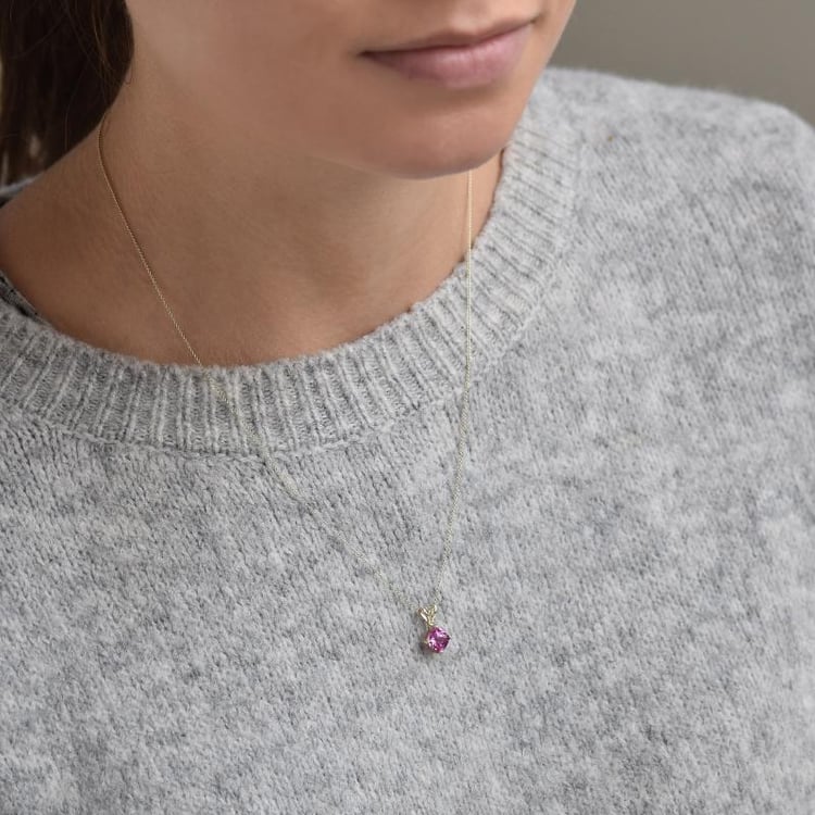 Goldene Kette mit rosa Saphir auf dem Hals 36748