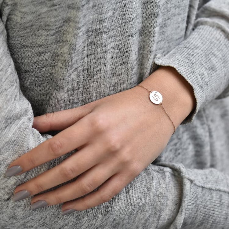 Goldenes Armband mit Krebs Sternzeichen auf dem Arm 37719