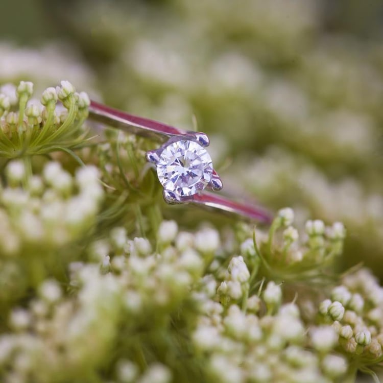 Verlobungsring mit Diamant auf dem blumen Hintergrund 12975