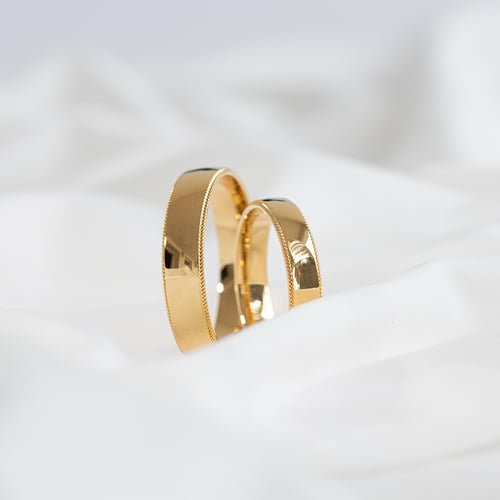 Goldene Eheringe mit einem verzierten Rand Rayan