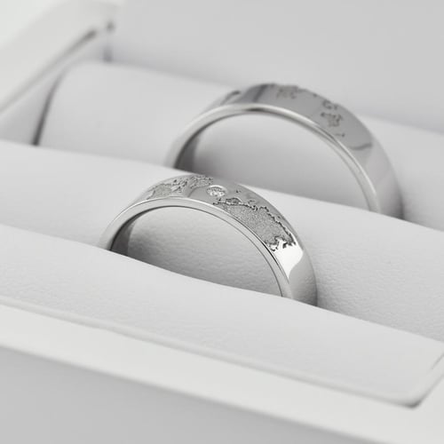 Goldene Trauringe mit Gravur der Weltkarte und Diamant Zeoni
