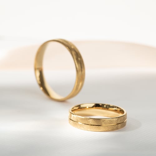 Goldene Eheringe mit gekratzter Oberfläche Alesha