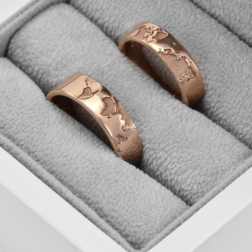 Goldene Trauringe mit Gravur der Weltkarte und Diamant Zeoni